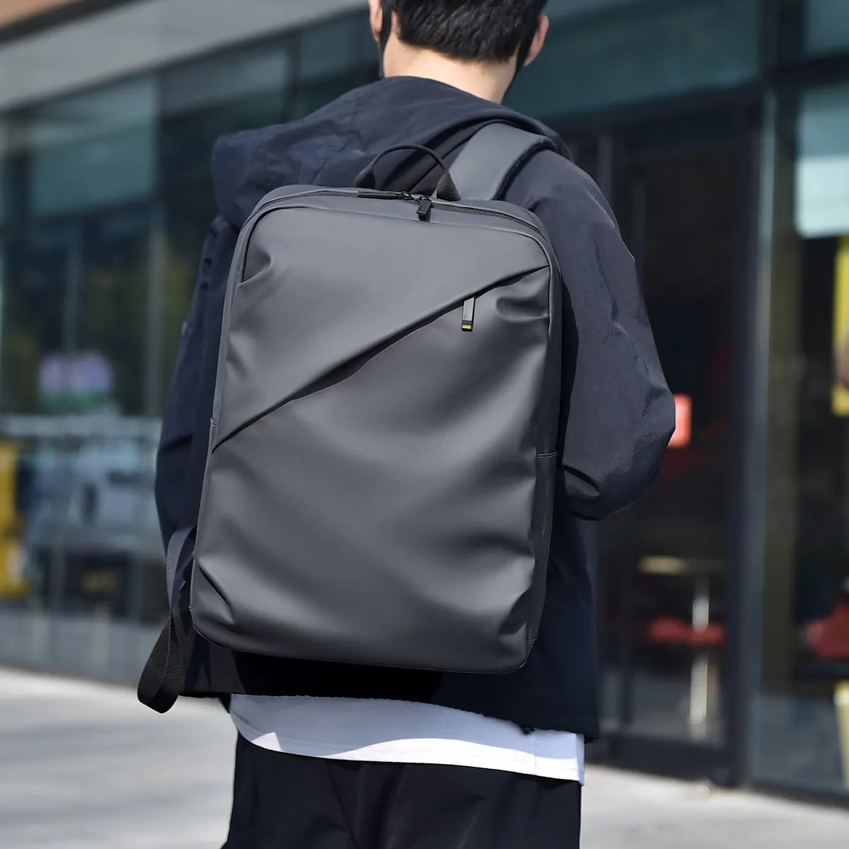 Large black waterproof PU leather backpack for men with sewing thread detailing and computer bag