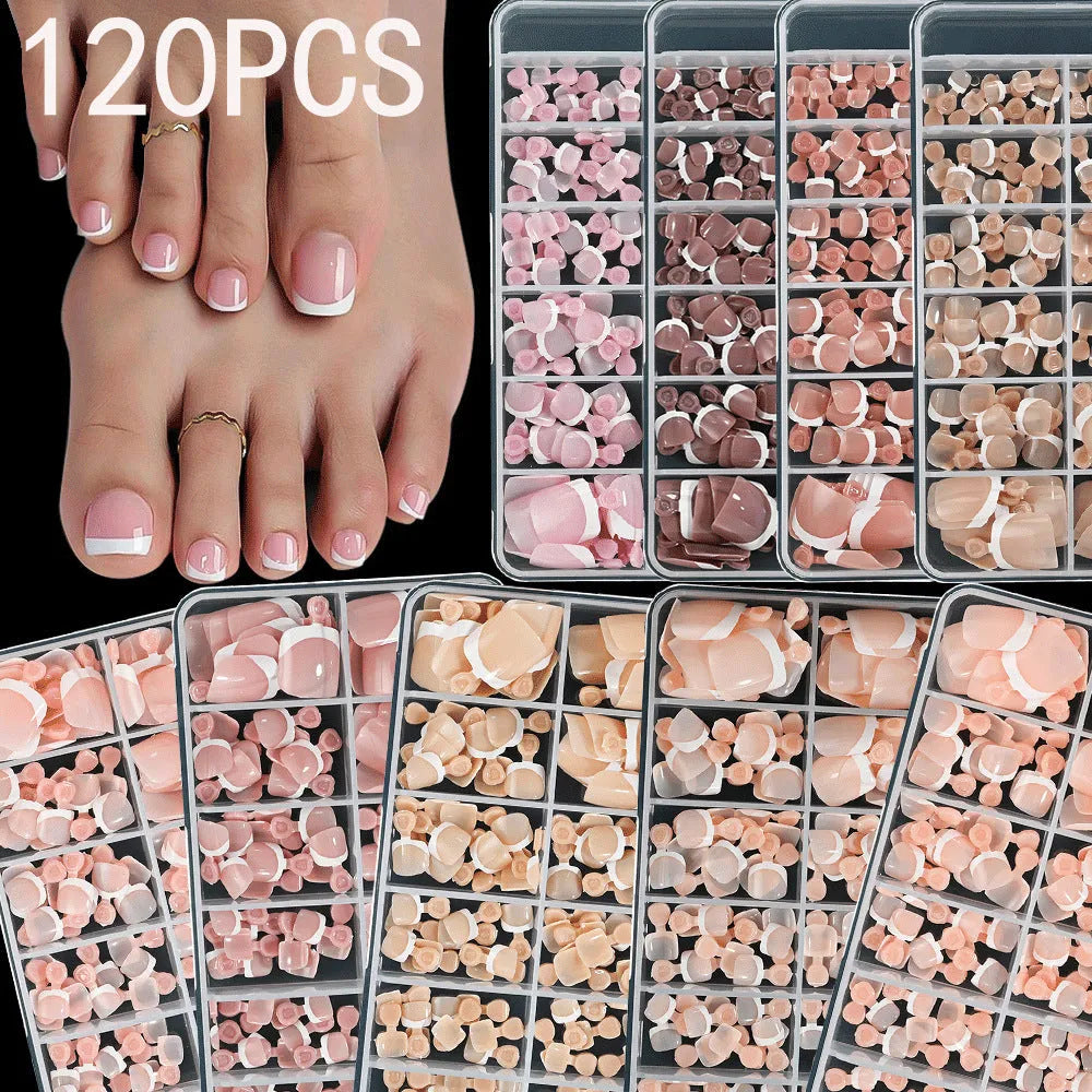 Box of 120 French white edge nude false toe nail pieces in assorted shades on a table