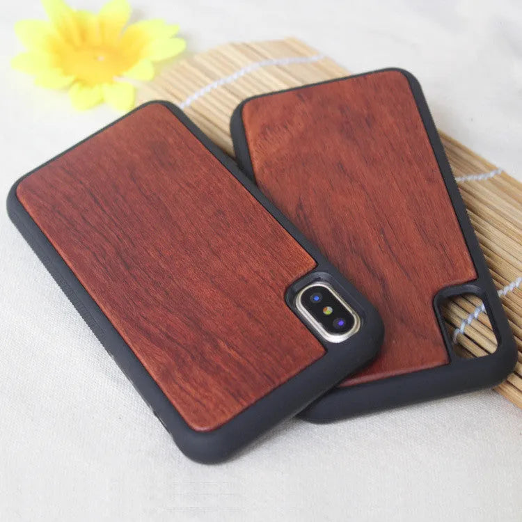 Wooden iPhone case with carbonised bamboo back and black TPU sides on a wooden table.