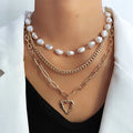 Vintage gold heart pearl necklace with adjustable chain on white background