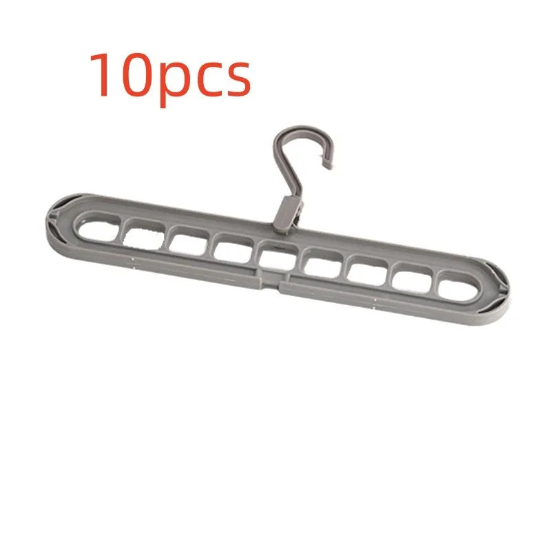 Green plastic nine-hole folding hanger for trousers shown in a dormitory wardrobe.