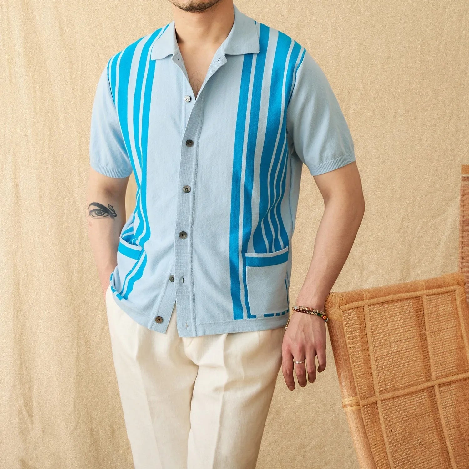 Royal blue striped short-sleeved knitted cardigan polo shirt with a lapel collar laid flat.