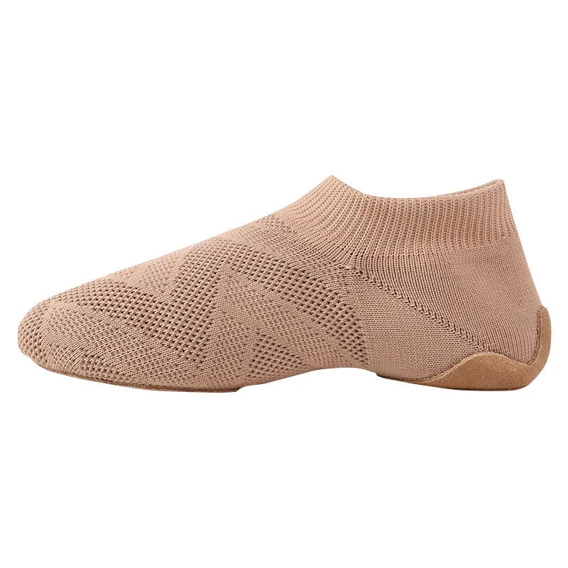 Camel colour dance yoga shoes with cotton mesh upper and leather sole on a plain background.