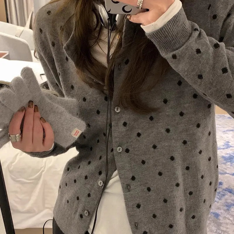 Women's loose fit grey knitted cardigan with crocheted flower details on the front.