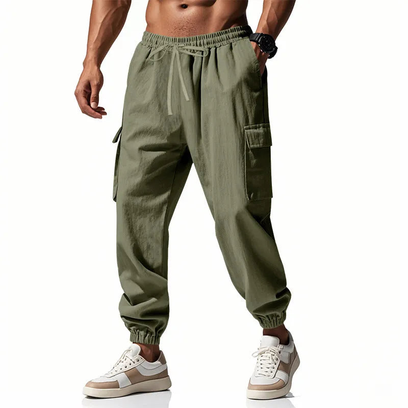Man wearing loose-fit linen casual trousers with ankle-tied cuffs and multiple pockets in a solid colour.