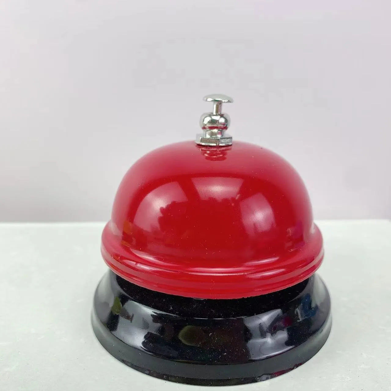 Iron game bell in one of ten colours: red, green, blue, pink, yellow, or other variants.