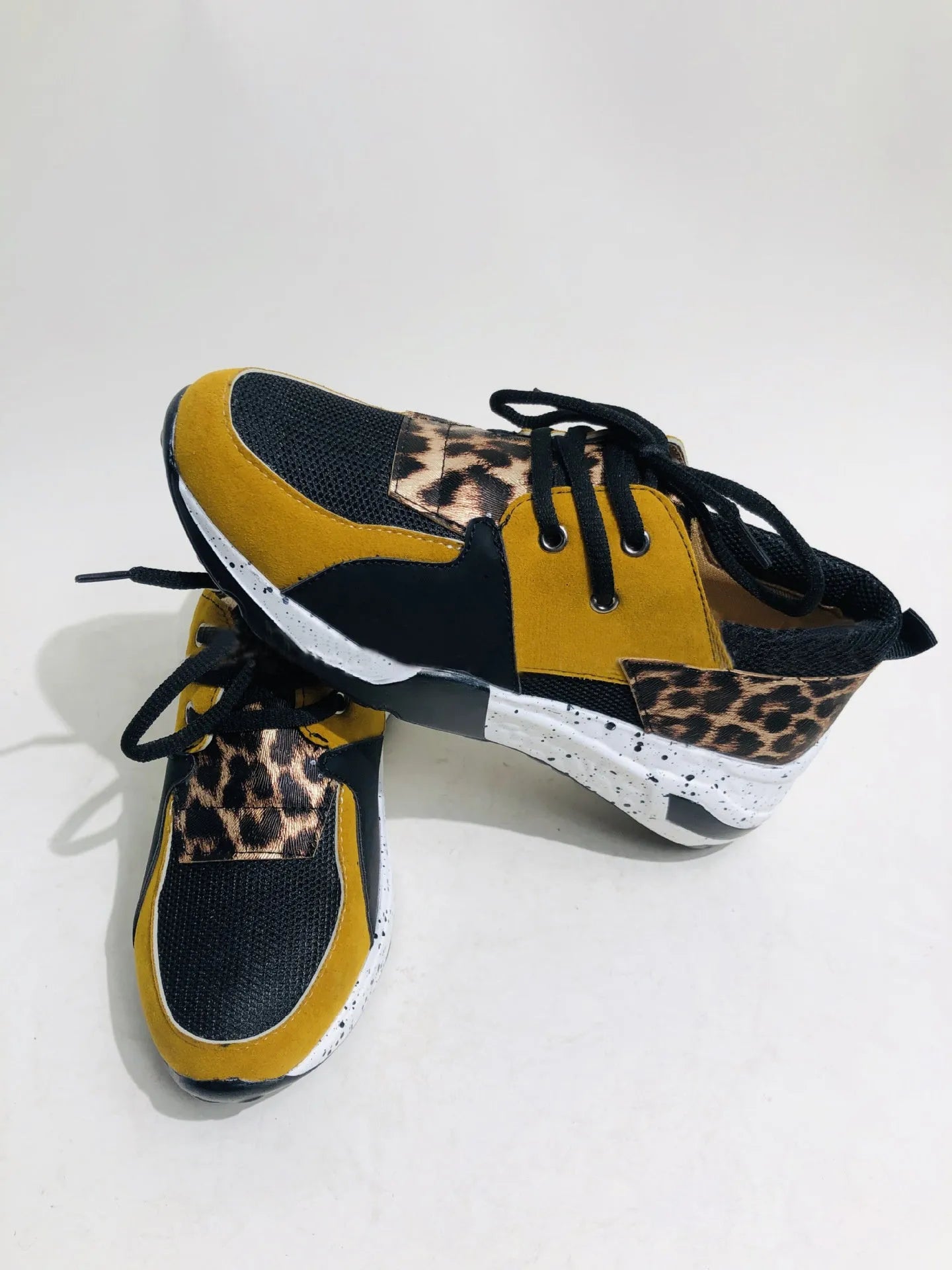 Women's black suede casual sneakers with a wedge heel on a white background