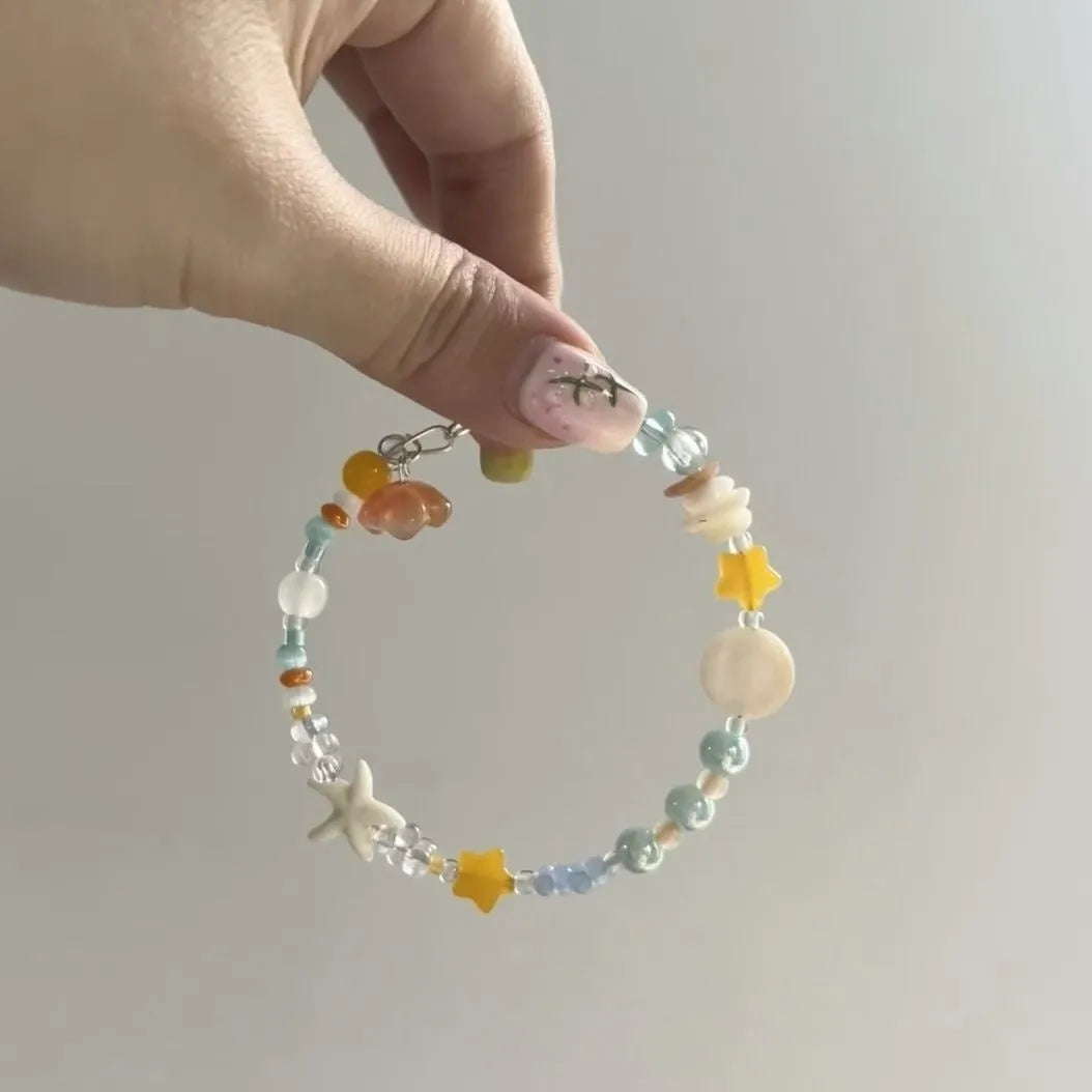 Orange mixed material alloy bracelet for women with diamond shapes and round elements.