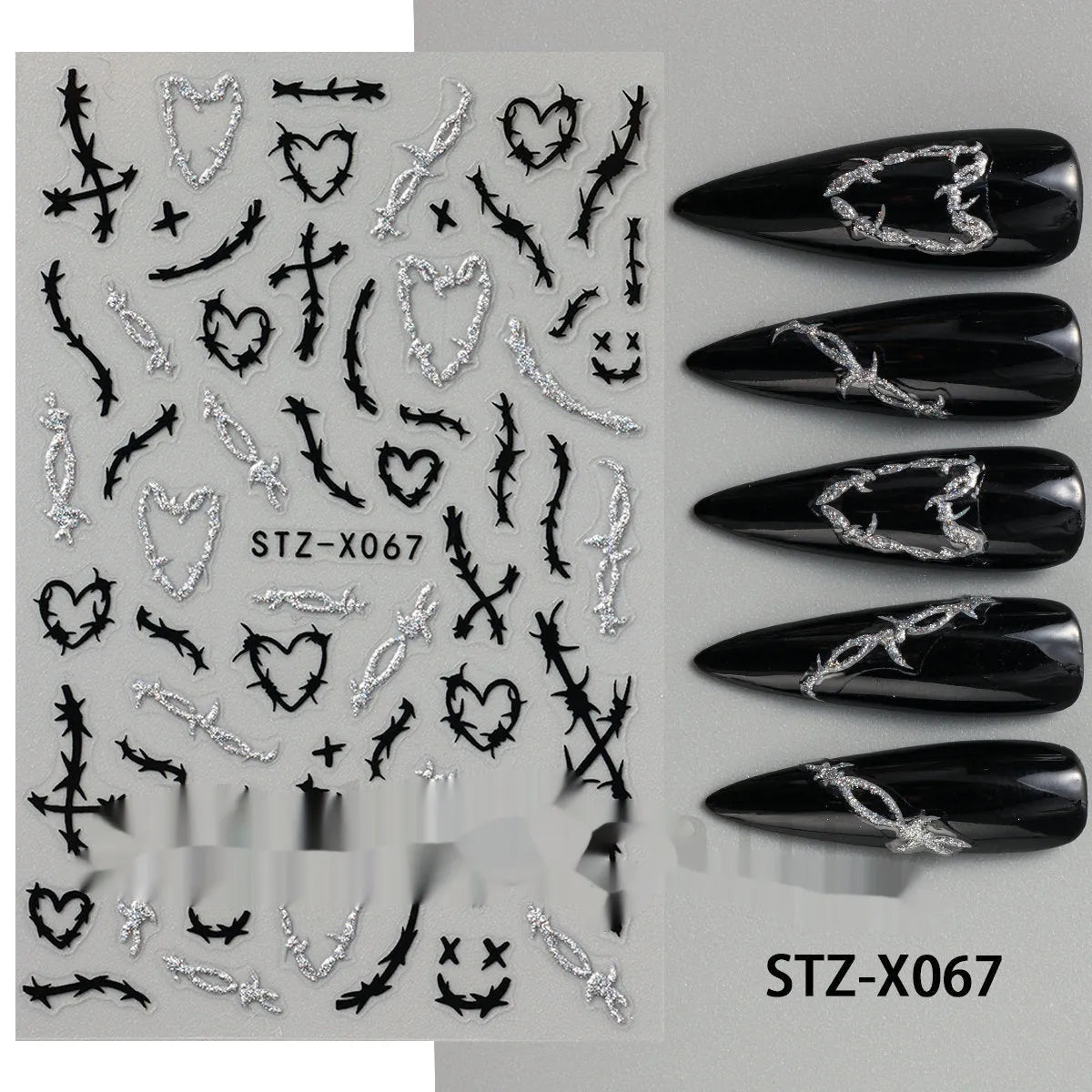 Close-up of a cartoon-style nail sticker with black and silver strips and a love pattern design on a fingernail.