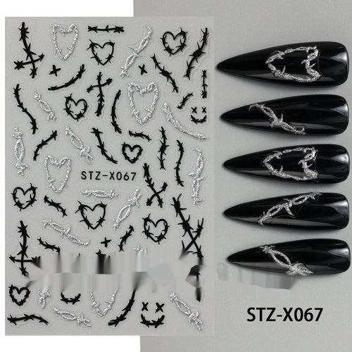 Close-up of a cartoon-style nail sticker with black and silver strips and a love pattern design on a fingernail.