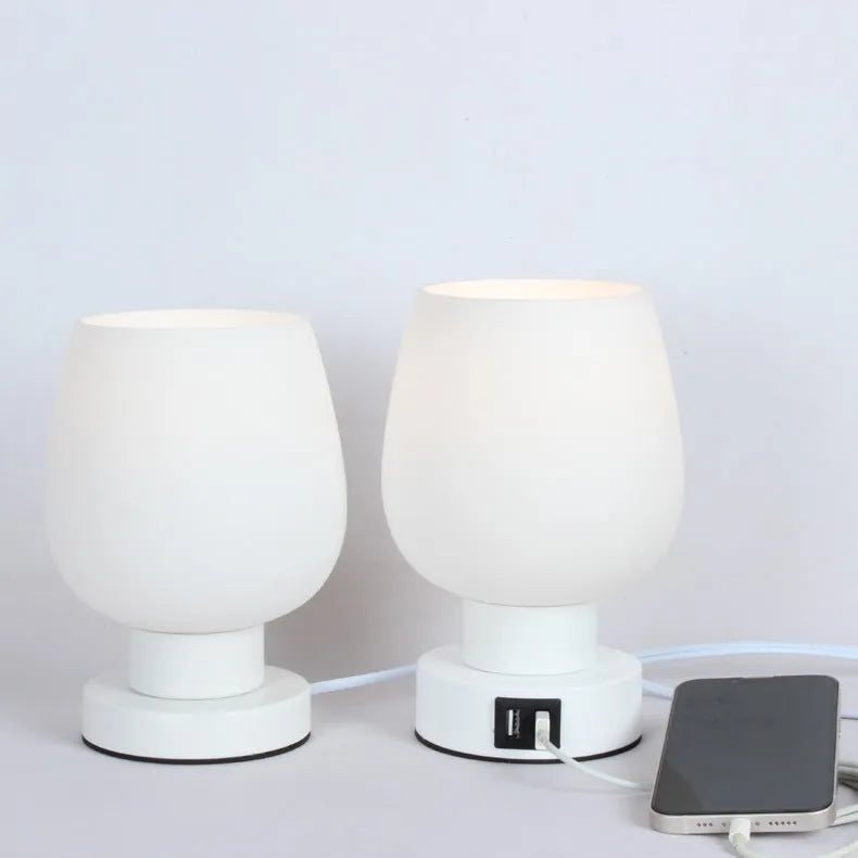 Nordic touch glass desk lamp with three colour settings and USB port on bedside table
