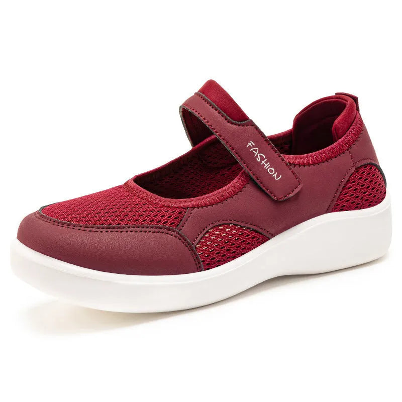 Women's grey casual slip-on shoe with mesh upper and Velcro strap on a flat sole.