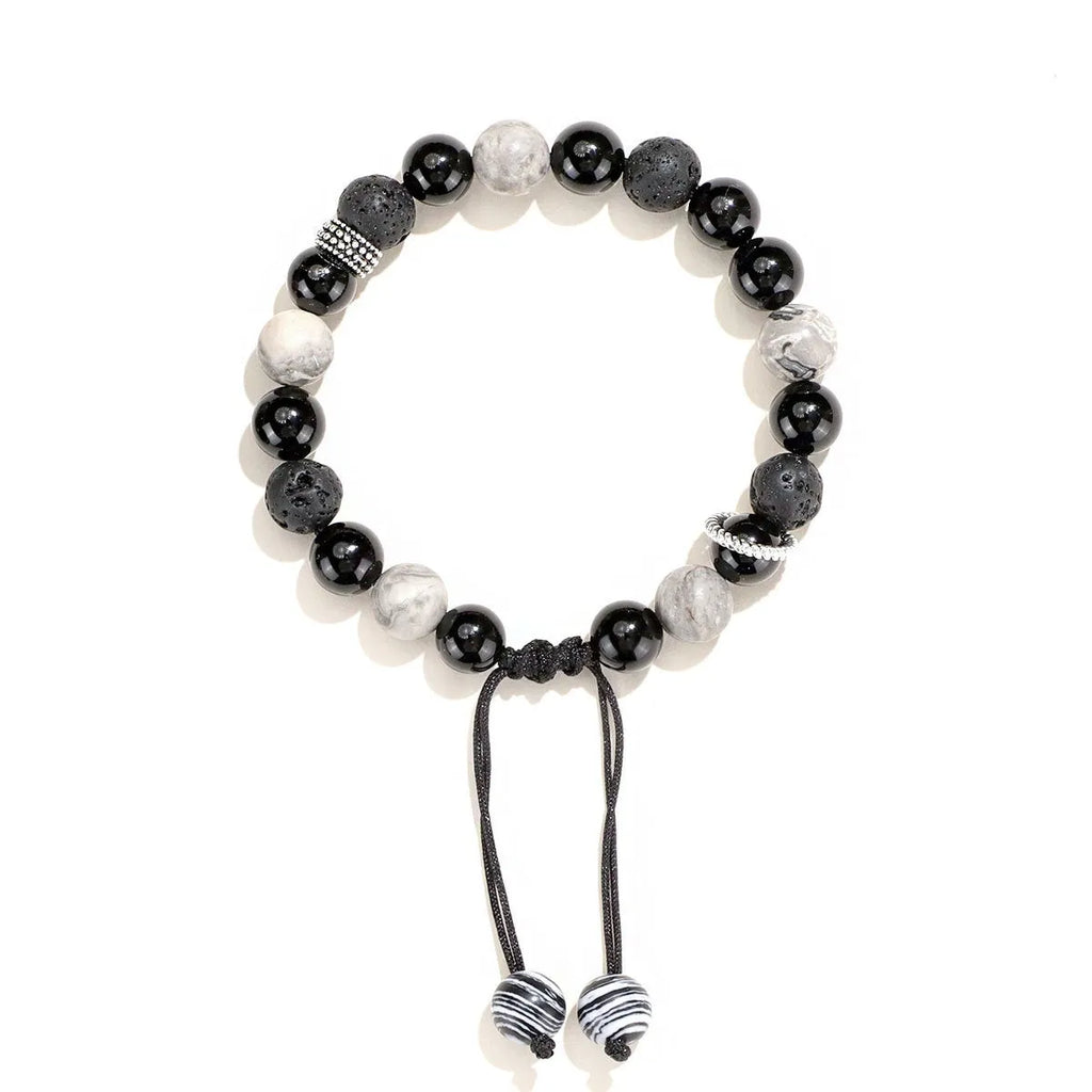 Black agate map stone and volcanic rock bracelet in diamond shape on a wrist.