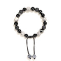 Black agate map stone and volcanic rock bracelet in diamond shape on a wrist.