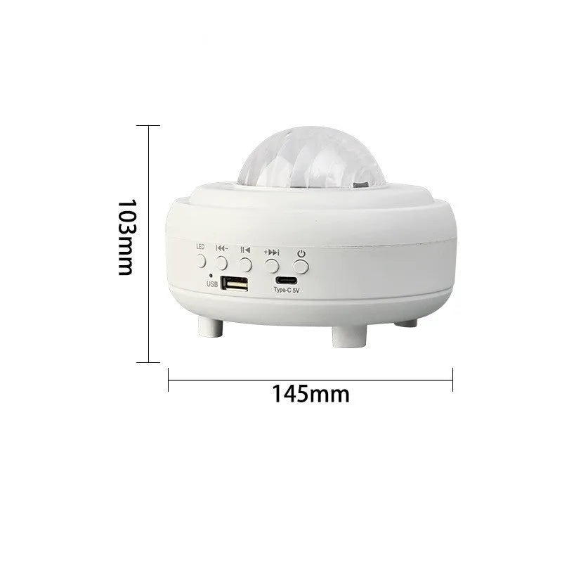 White and black rechargeable galaxy star projector night light with Bluetooth speaker on a table.