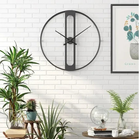 Round metal wall clock with 50cm diameter in black or gold colour on a wall.