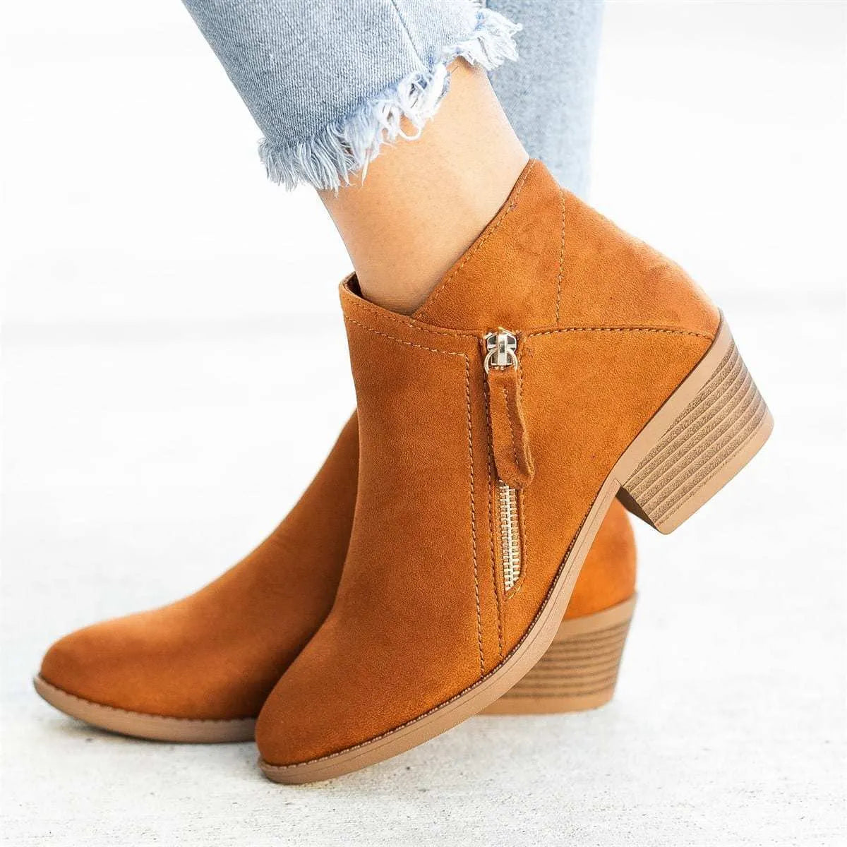 Women's blue suede ankle boot with chunky heel and side zip, on a white background.