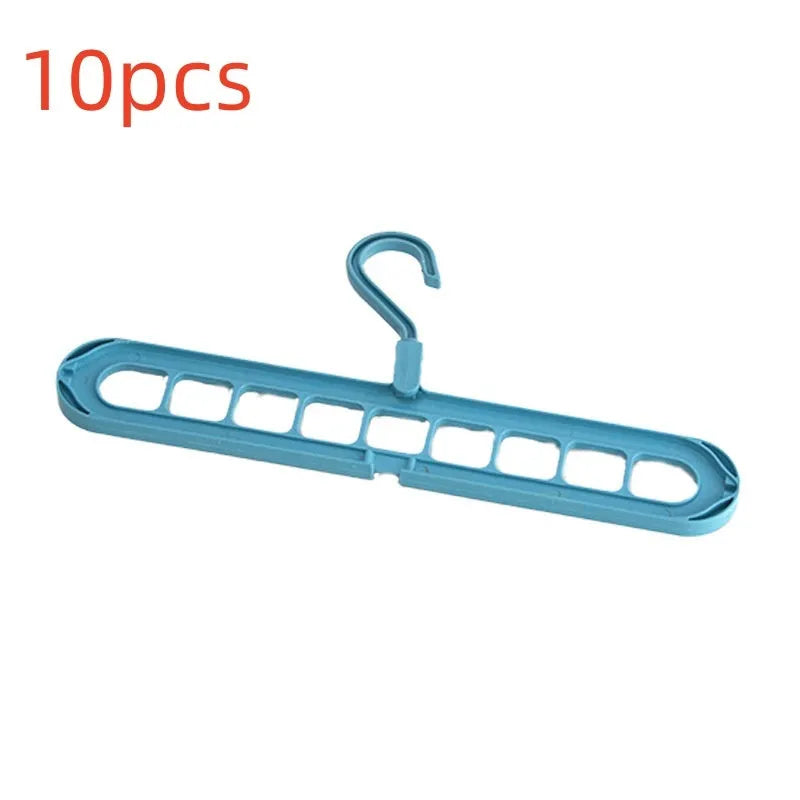 Green plastic nine-hole folding hanger for trousers shown in a dormitory wardrobe.