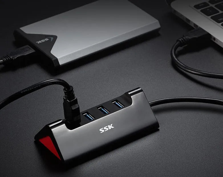 Black USB expansion hub with four ports showing USB 3.0 and USB 2.0 interfaces on ABS plastic casing