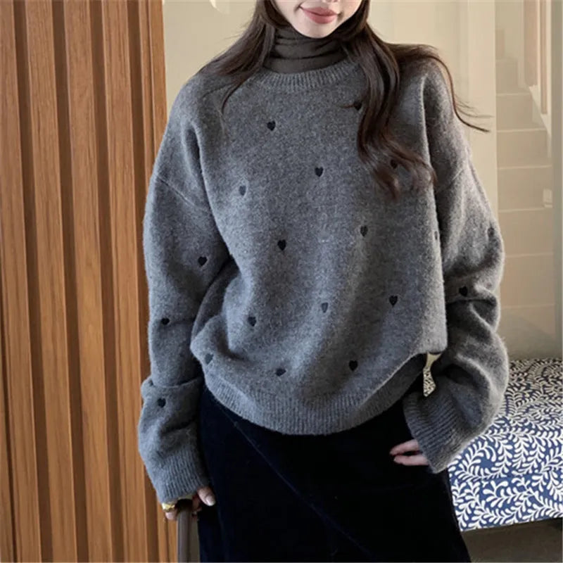 Women's loose grey acrylic pullover sweater with embroidery on the front, long sleeves, and a crew neck.