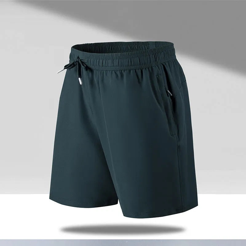Man wearing loose fit black quick-dry sports shorts on a beach.
