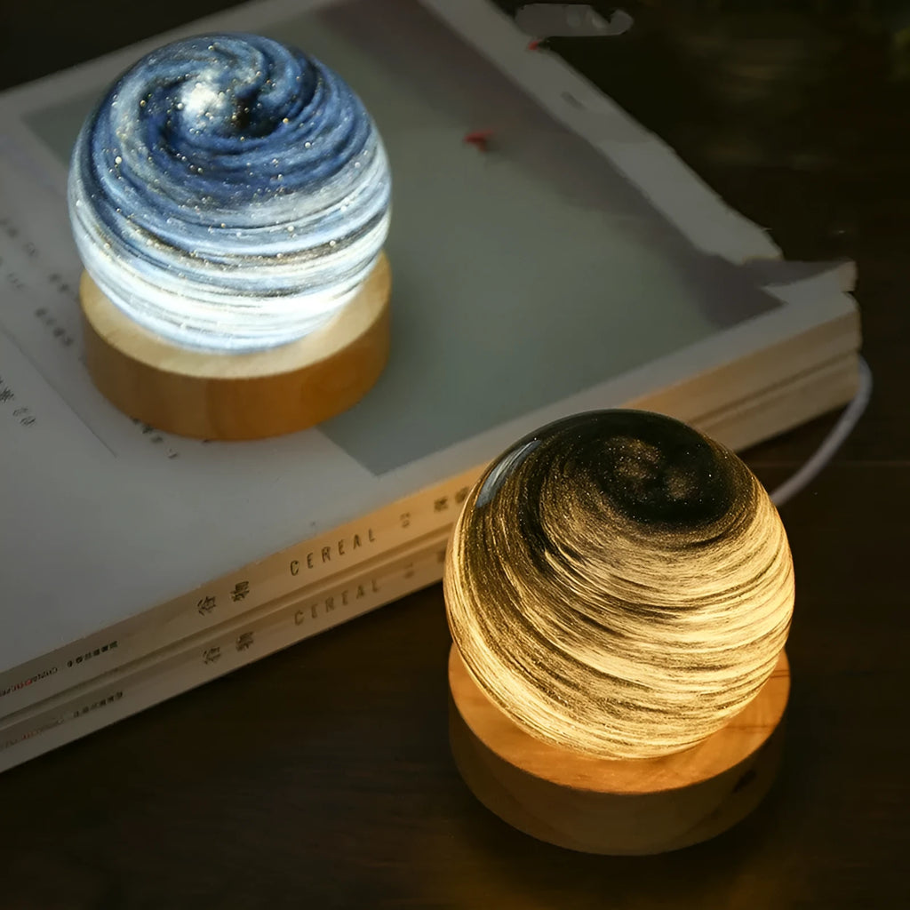 Modern simple planet-shaped USB night light on its base with soft glow.