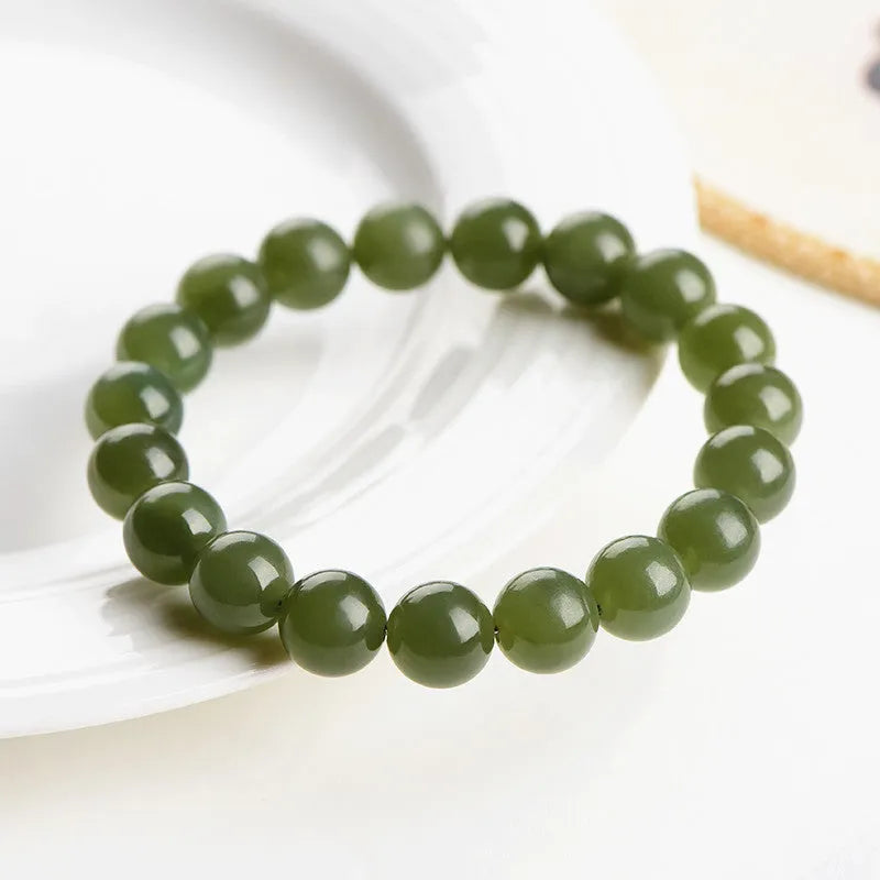 Polished Hetian jade ball bracelet on a wrist, showing ice-like clear beads in one of four available sizes.
