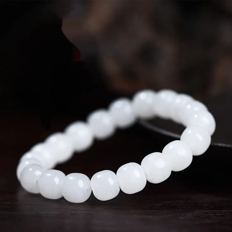 White Hetian jade barrel bead bracelet laid flat, showing unisex casual design.