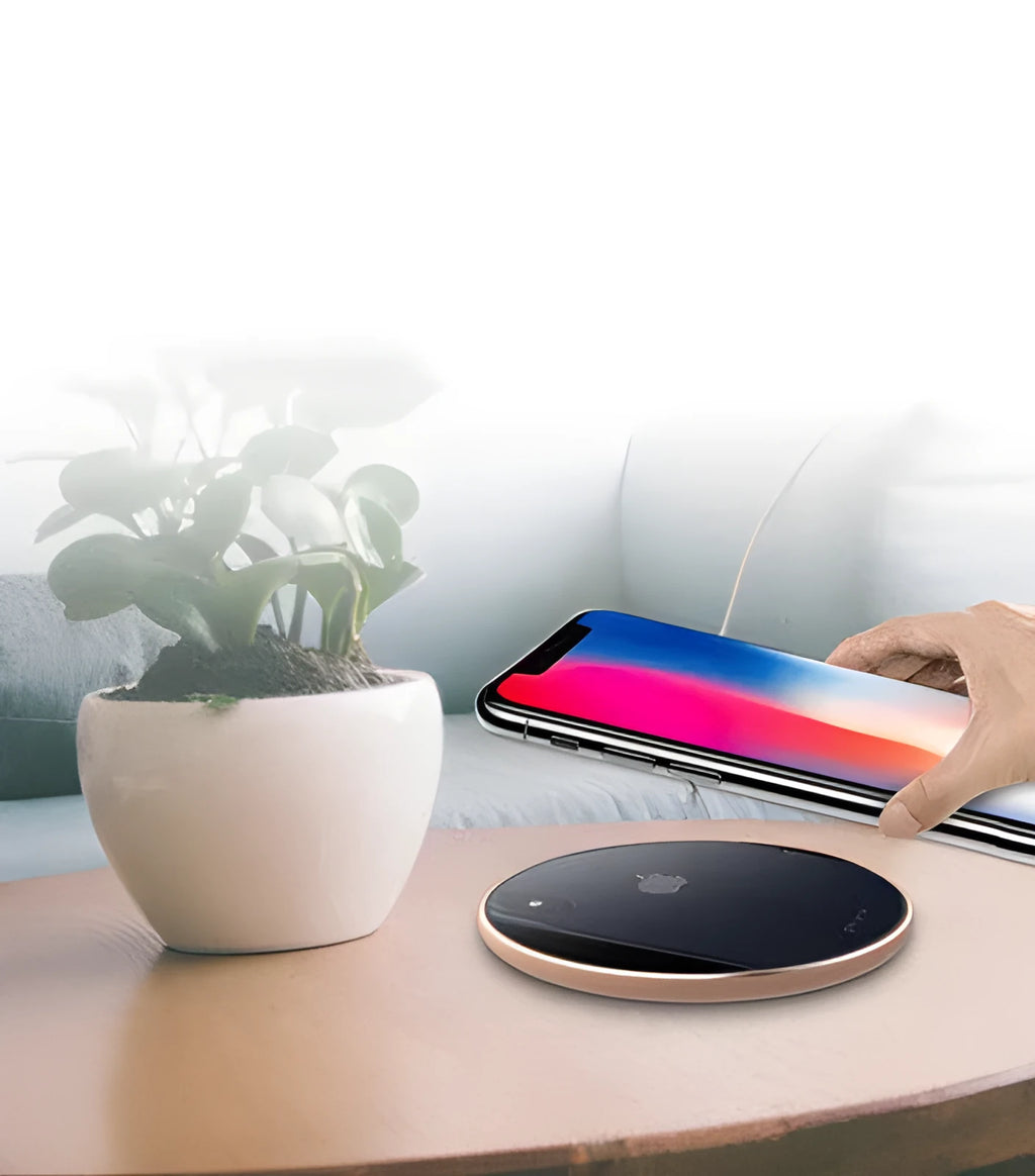 Ultra-thin aluminum wireless charger in silver on a desk next to a phone.