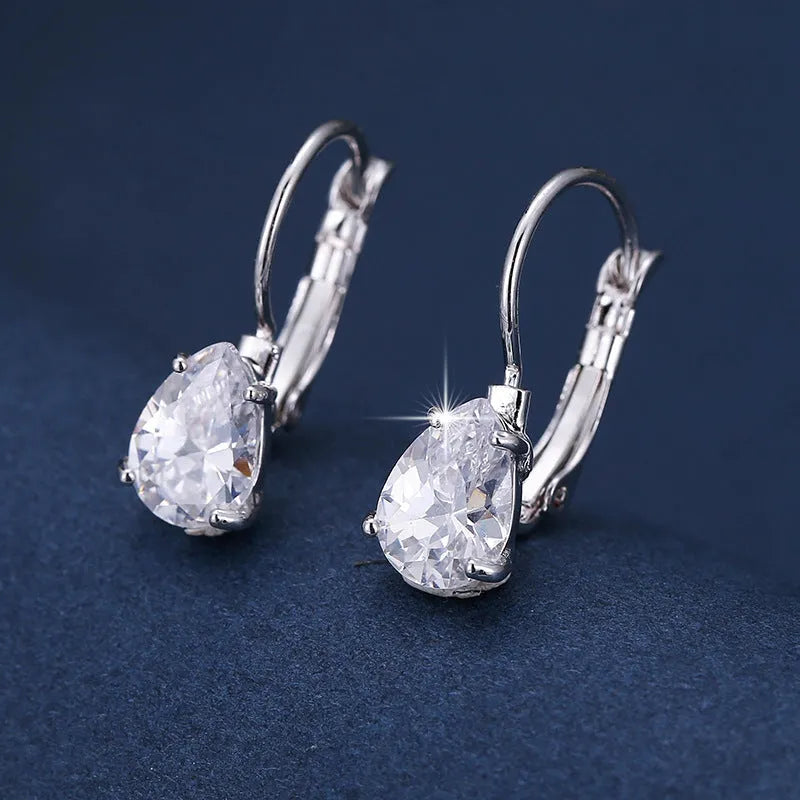 Drop-shaped metal earrings in gold or platinum finish with inlaid gem detailing