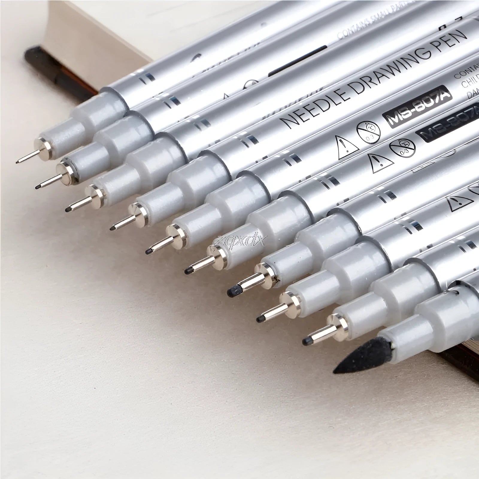 Set of 10 black fine liner drawing pens with tip sizes from 0.05mm to 2.0mm on white background