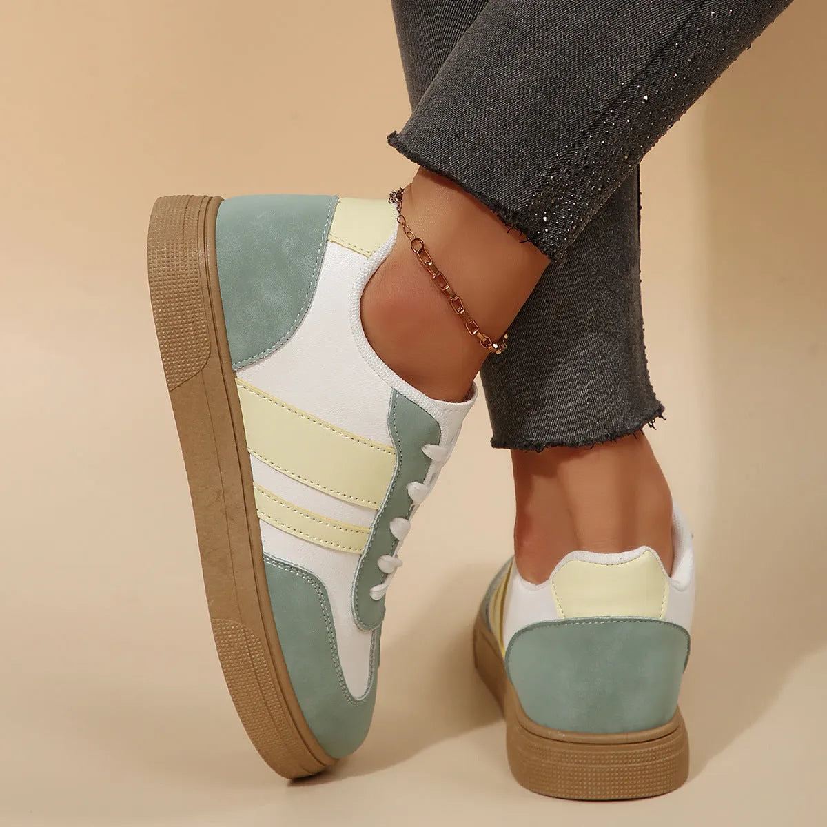 Women's retro sports shoes in white with green candy colour accents and cross-strap details on PU leather upper.
