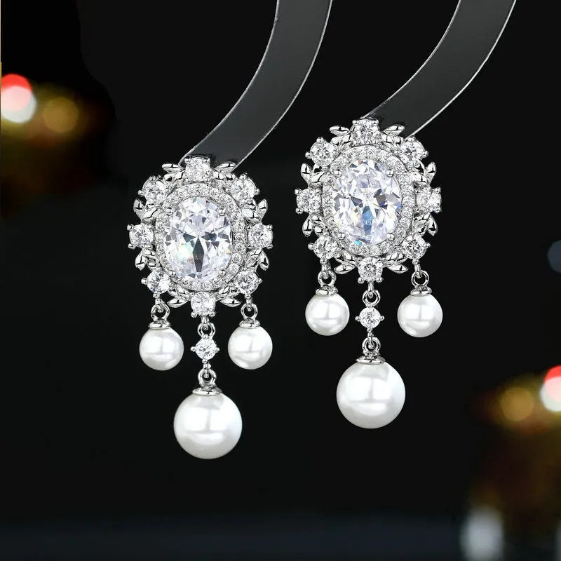 Oval geometric copper drop earrings with pearl elements, inlaid zircon treatment, and tassel detailing in light purple colour