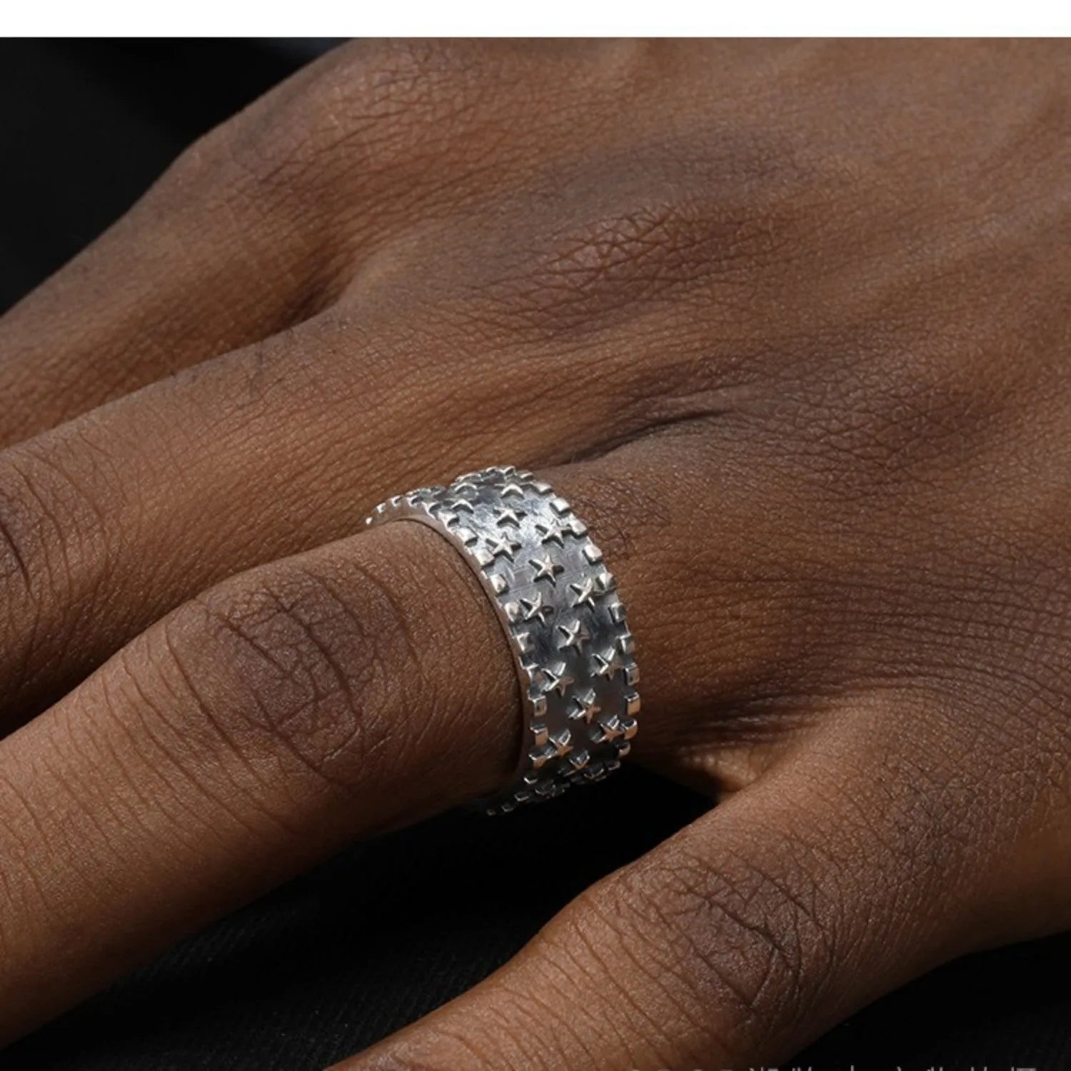 Adjustable sterling silver ring with geometric five-pointed star pattern on band