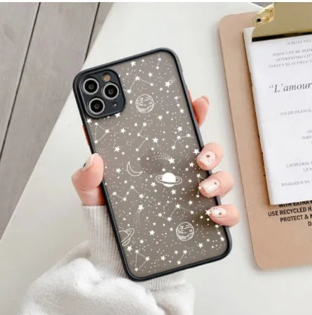 Black and white Star Universe anti-blue light phone case for iPhone models on a table.