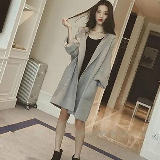 Plus size woman modelling a loose grey cotton coat with lace detailing and long sleeves.