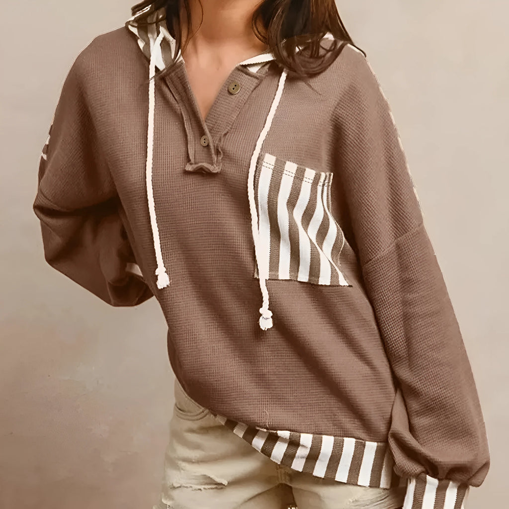 Straw yellow hoodie with waffle texture fabric, striped patchwork design, and button neck closure.