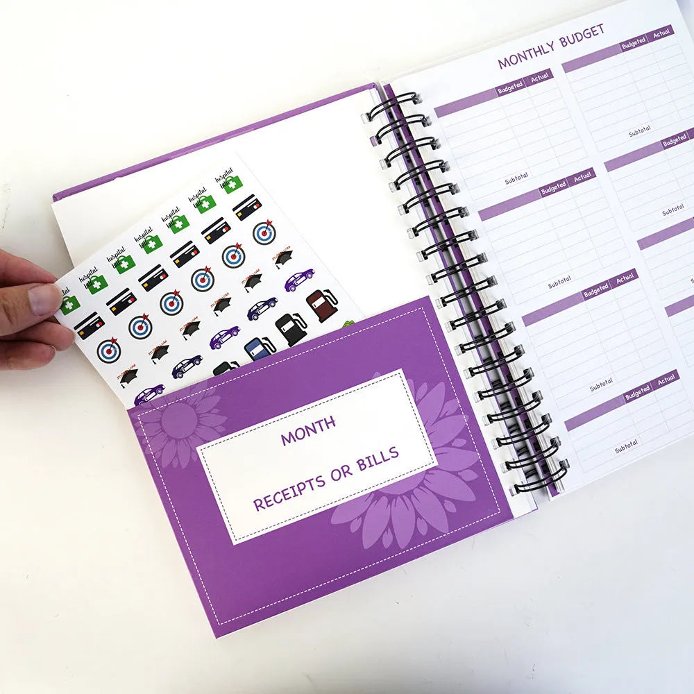 J12 purple coil-bound financial planning notebook with budget stickers and paper clips