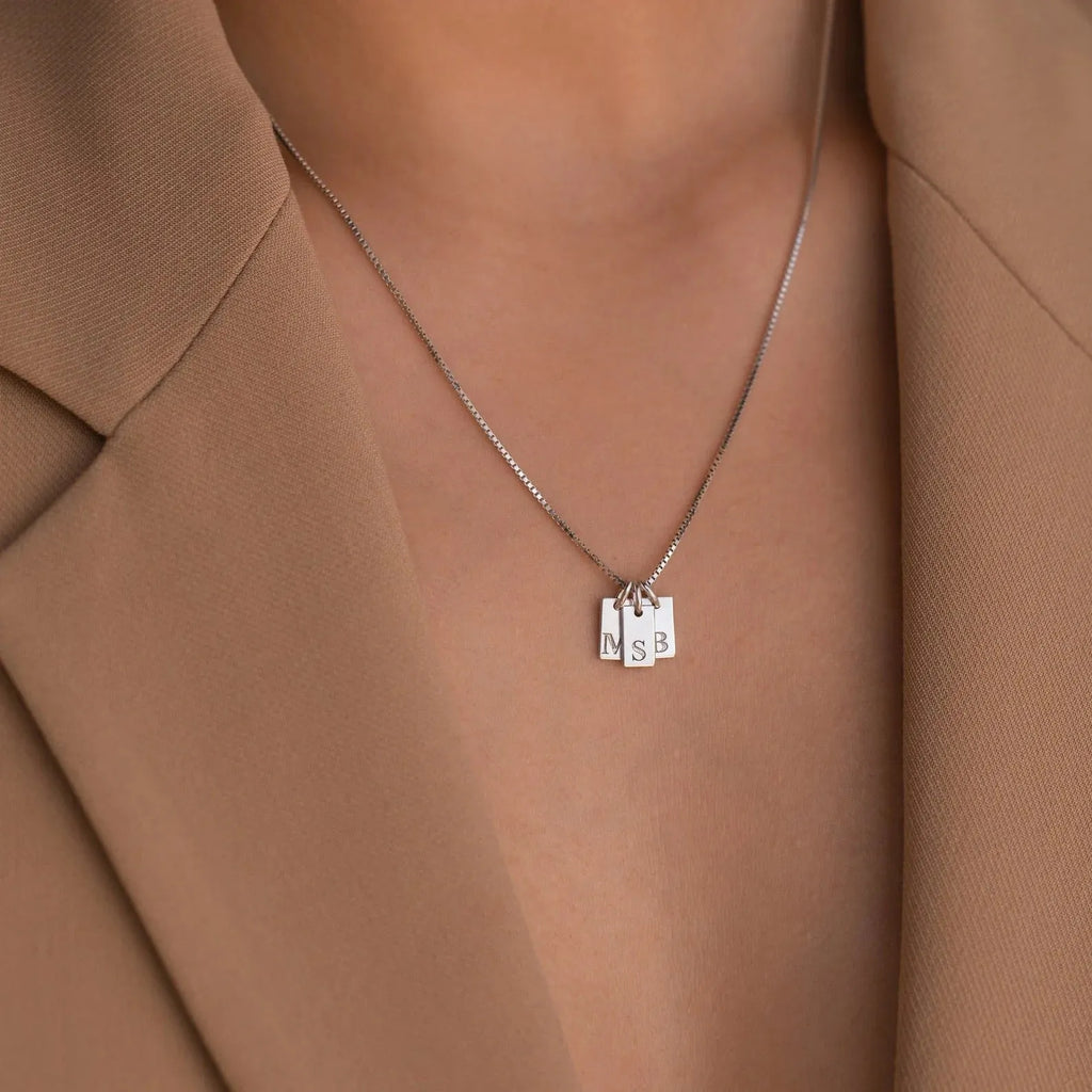 Mini square stainless steel initial necklace with gold plating on a sparkling box chain