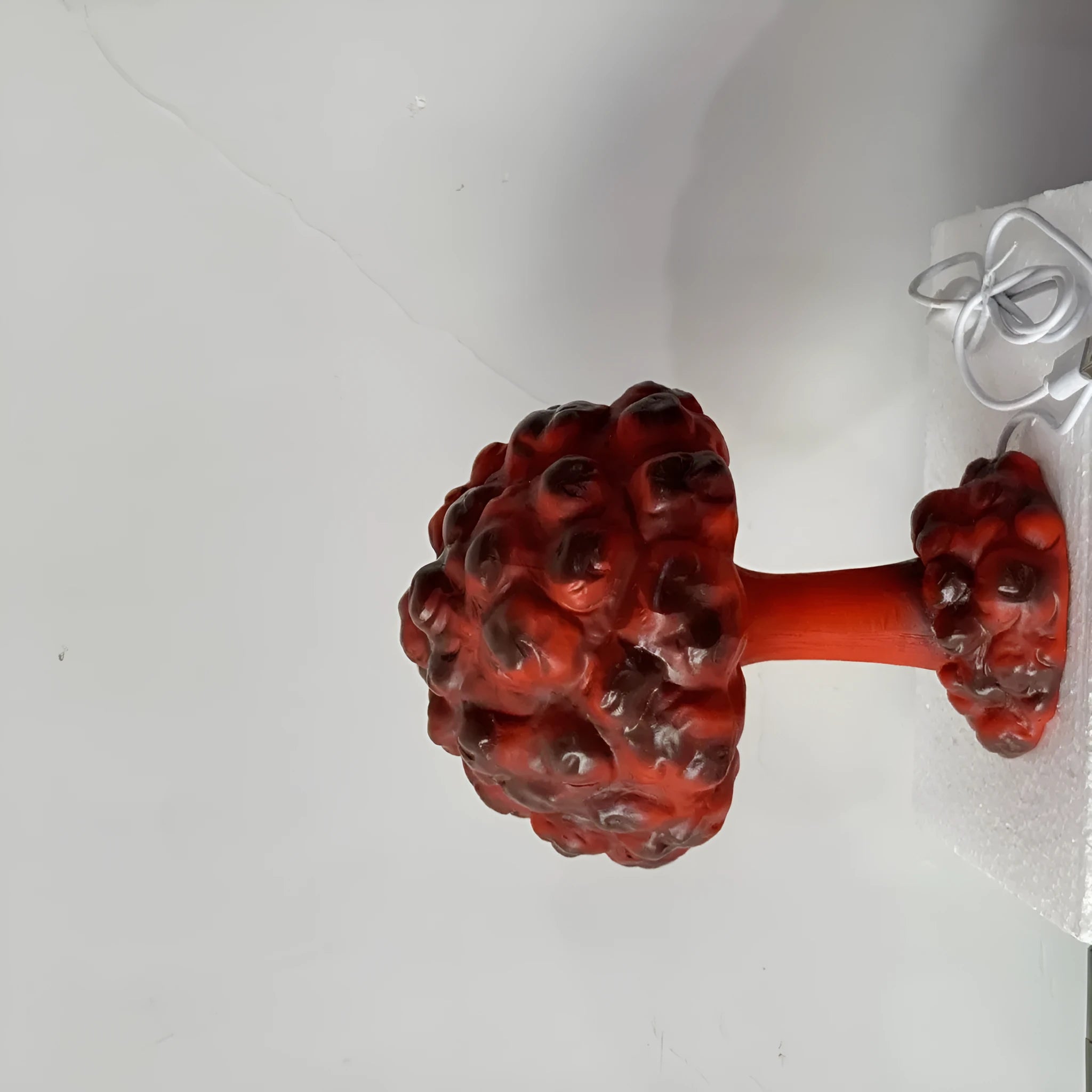 Modern art mushroom cloud table lamp with USB power cable on a desk.