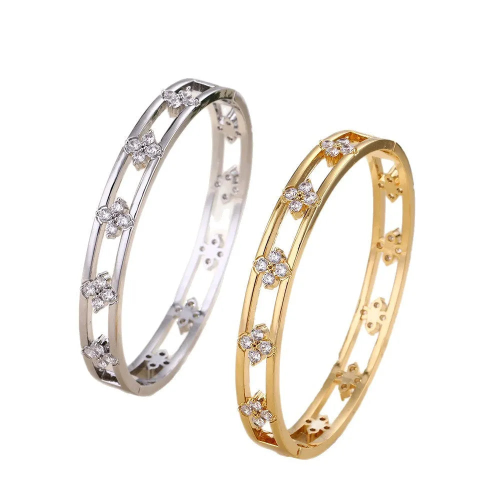 Women's hollow bracelet with four-leaf clover charm and zircon inlay detailing on copper-plated gold