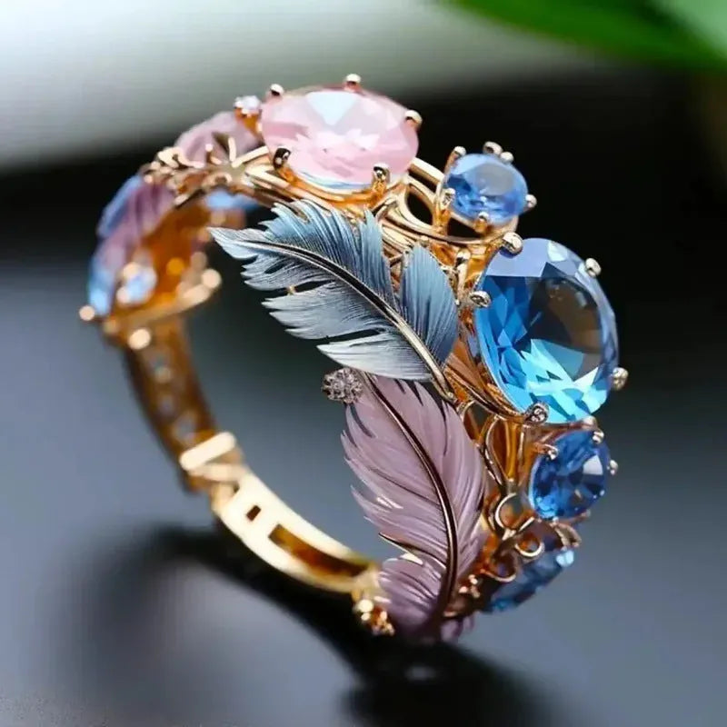 Gold coloured brass feather ring with embossed geometric design and colourful zircon inlays.