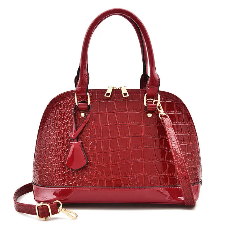 Shiny black PU leather crossbody shoulder bag with a structured shell shape.