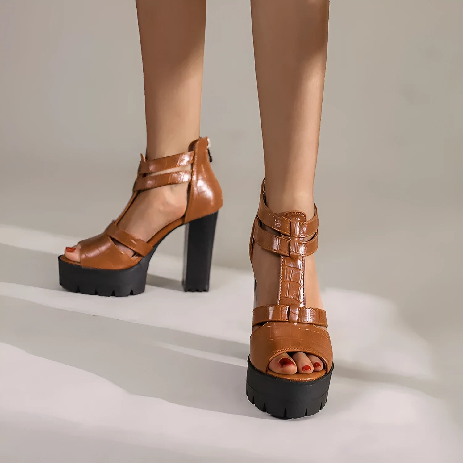 Women's black platform high heel sandals with ankle strap and back zipper on a round toe.