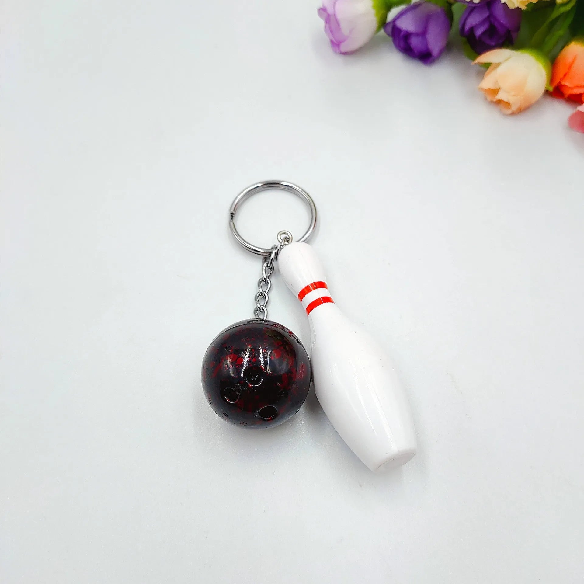 Mini bowling pin simulation keychain pendant in blue, made from PVC and metal on a key ring.
