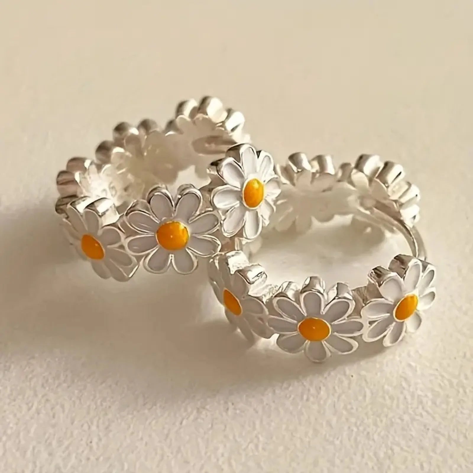 White platinum-electroplated daisy flower ring earrings with gemstone details on a copper base.