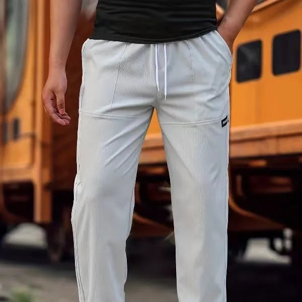 Men's polyester trousers for spring and autumn in light grey, shown flat.
