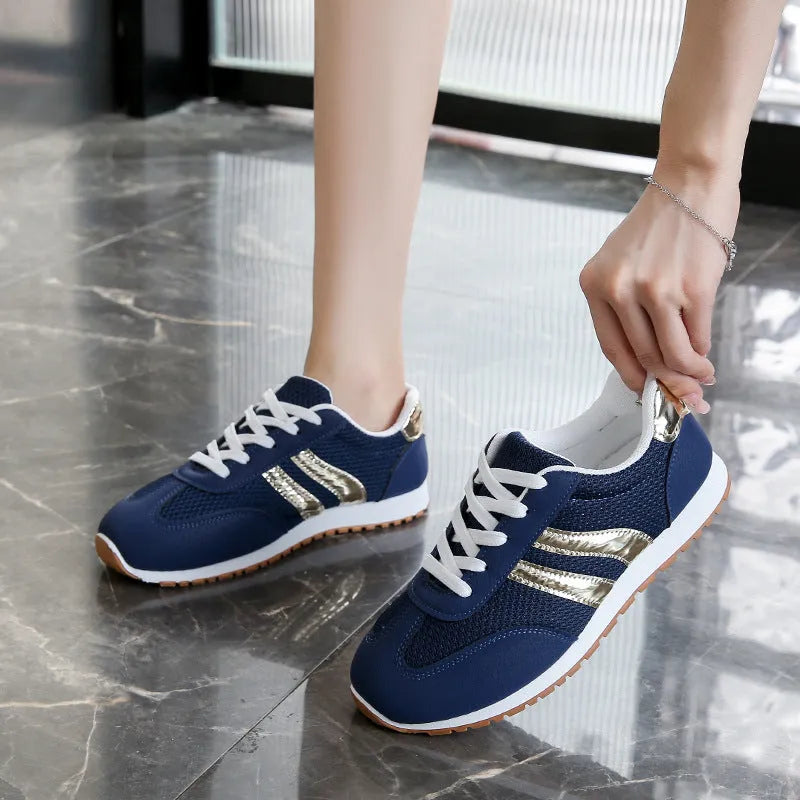 Blue women's artificial leather tennis shoes with cross shoulder straps and flat rubber sole.