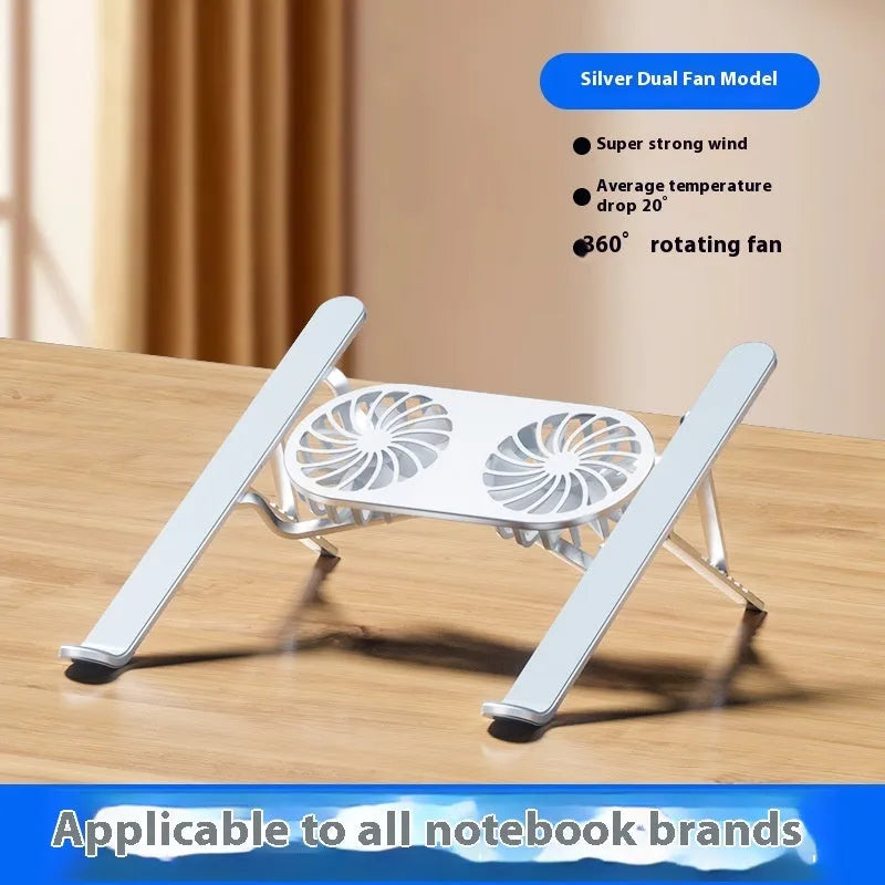Silver aluminium laptop stand with twin fans raised at an angle on a wooden desk.