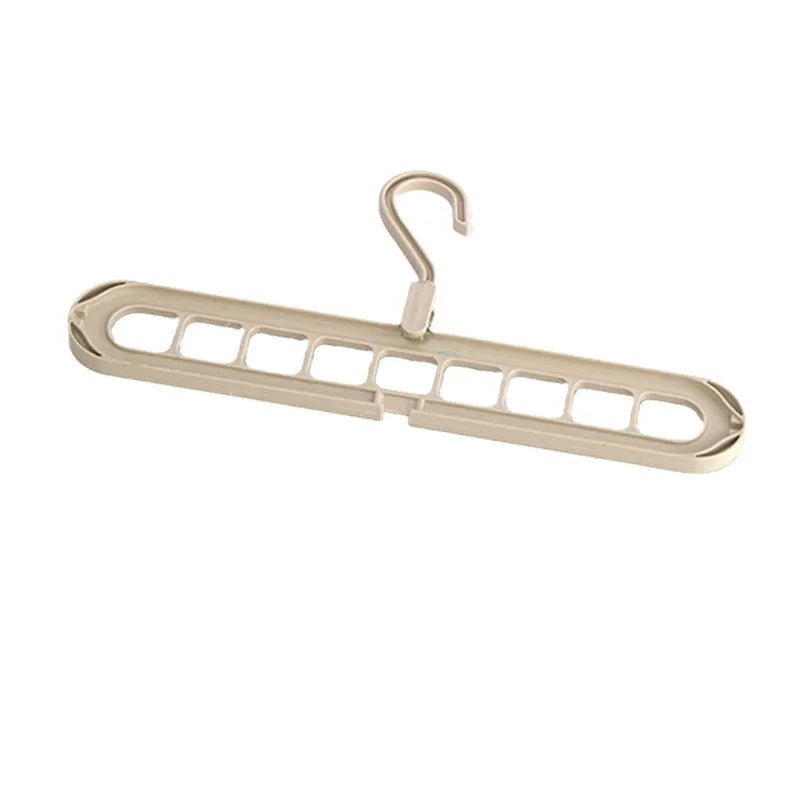 Green plastic nine-hole folding hanger for trousers shown in a dormitory wardrobe.